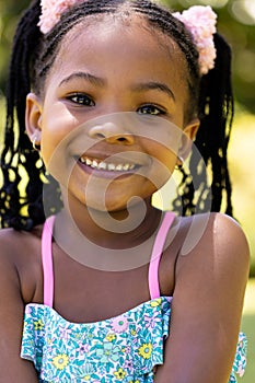 Closeup portrait of smiling african american cute girl with dreadlocks looking at camera