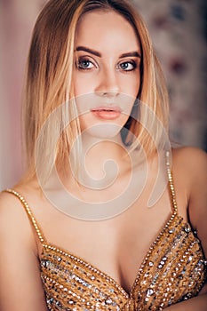 Closeup portrait of smiling blonde woman at party. Beautiful girl with a gentle makeup looking at the camera