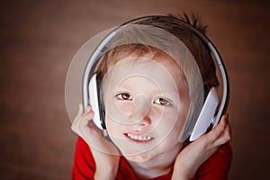 Closeup Portrait of a smiling boy listening to music on headphon