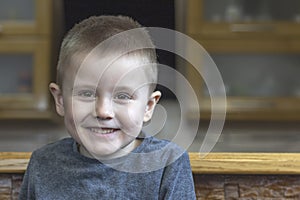 Closeup portrait of smiling child. Portrait of pretty little boy in the kitchen at home.