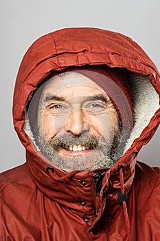 Closeup portrait of smiling man in winter coat freezing in the cold