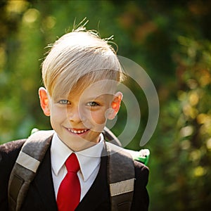 Closeup portrait of smiling pupil. Cute boy going back to school.