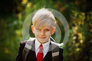 Closeup portrait of smiling pupil.Cute boy going back to school. Child with backpack on first school day.