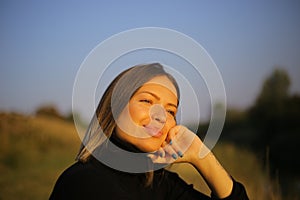 Closeup portrait of a smiling relaxed woman in a turtleneck holding hand under chin