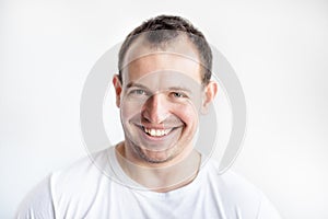 Closeup portrait of smiling 30 years old caucasian white man on white background in white t-shirt. Confident happy smart modern