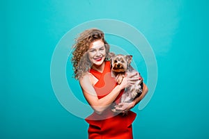 Closeup portrait of smiling young attractive woman looking at camera and embracing Yorkshire terrier. Pet concept. Isolated front