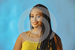 closeup portrait of smiling young beautiful african american woman braid hair posing at studio looking at camera