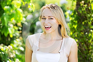 Portrait of glad young blond woman in garden