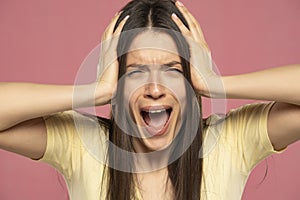Closeup portrait stressed frustrated woman screaming having temper tantrum isolated on pink background