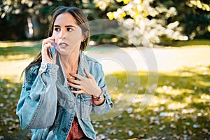 Closeup portrait of stressed woman holding cellphone worried received bad news in the city park. Human emotion face expression,