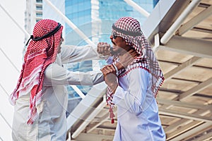 Closeup portrait of two Arab guys fighting, Aggressive behavior, on city background