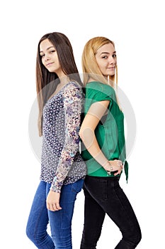 Closeup portrait of two teenage girls standing back to back