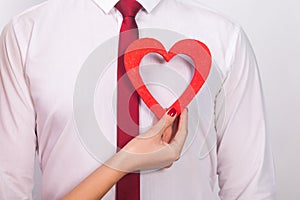 Closeup portrait of unknown man, woman hand , holding his heart