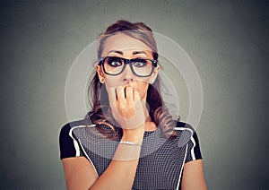 Closeup portrait unsure hesitant anxious woman biting her fingernails