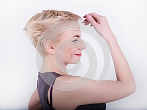 Closeup portrait of whiteheaded young woman with red lips, holding a hand near the hair