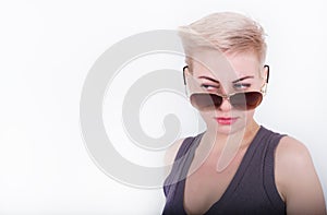 Closeup portrait of whiteheaded young woman with red lips, looking over sunglasses