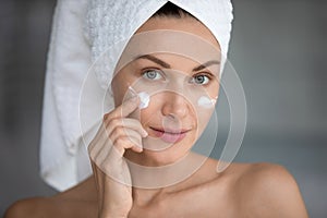 Closeup portrait woman applying night or day face cream