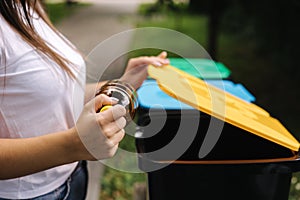 Closeup portrait woman hand throwing empty plastic water bottle in recycling bin