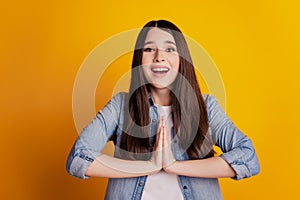 Closeup portrait woman hold palms together plead isolated yellow wall background