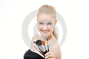 Closeup portrait of woman with makeup brush near face