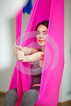 Closeup portrait of woman posing in hammock, aerial antigravity yoga