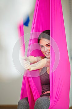 Closeup portrait of woman posing in hammock, aerial antigravity yoga