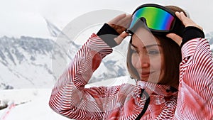 Closeup portrait of a woman who is preparing for a descent in the mountains. Skiing. Snowboard. Mountain climbing. The