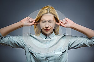 Closeup portrait of worried woman covering her ears, observing. Hear nothing