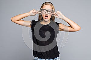 Closeup portrait, young angry, unhappy, stressed woman covering closed ears, looking away annoyed by loud noise, giving her headac