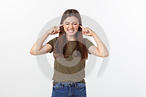 Closeup portrait of a young angry woman covering her ears, stop making that loud noise it`s giving me a headache