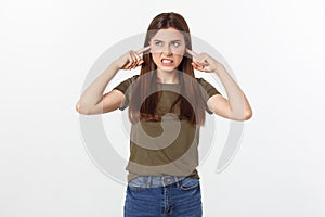 Closeup portrait of a young angry woman covering her ears, stop making that loud noise it`s giving me a headache
