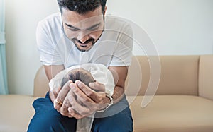 Closeup portrait of young asian Indian father holding his newborn baby with copy space.