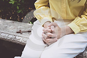 Closeup portrait of a young asian woman praying, against nature background