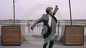 Closeup portrait of young attractive african american businessman dancing and making shuffle moves smiling happily on