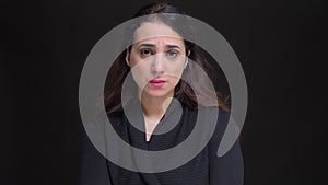 Closeup portrait of young attractive caucasian female getting upset and disappointed while looking at camera.