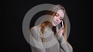 Closeup portrait of young attractive caucasian girl having a casual conversation on the phone in front of the camera
