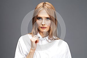 Closeup portrait of a young beautiful blonde woman in a white shirt