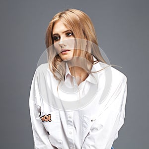 Closeup portrait of a young beautiful blonde woman in a white shirt