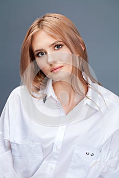 Closeup portrait of a young beautiful blonde woman in a white shirt