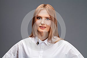 Closeup portrait of a young beautiful blonde woman in a white shirt