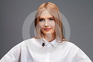 Closeup portrait of a young beautiful blonde woman in a white shirt