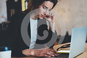 Closeup portrait of Young beautiful businesswoman using laptop computer at modern office.Blurred background.Horizontal.