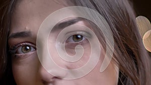 Closeup portrait of young beautiful caucasian female face with green eyes looking straight at camera