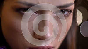 Closeup portrait of young beautiful caucasian female model looking straight at camera and posing