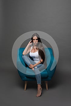 Closeup portrait of young beautiful woman with with beautiful long hair. Sitting and posing in studio. Portrait of trendy, cheerfu