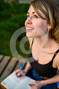 Closeup portrait of young beautiful woman relaxing on the bench