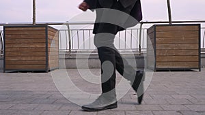 Closeup portrait of young cheerful attractive african american businessman performing a moonwalk on the street in the