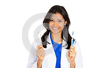 Closeup portrait of young confident, smiling, cheerful female oral health care professional, dentist, showing toothbrush and