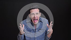 Closeup portrait of young funny caucasian man making different facial expression and playing a fool in front of the