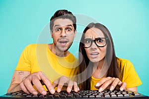 Closeup portrait of young geeks it specialists wear yellow t-shirt writing keyboard browsing esport betting isolated on